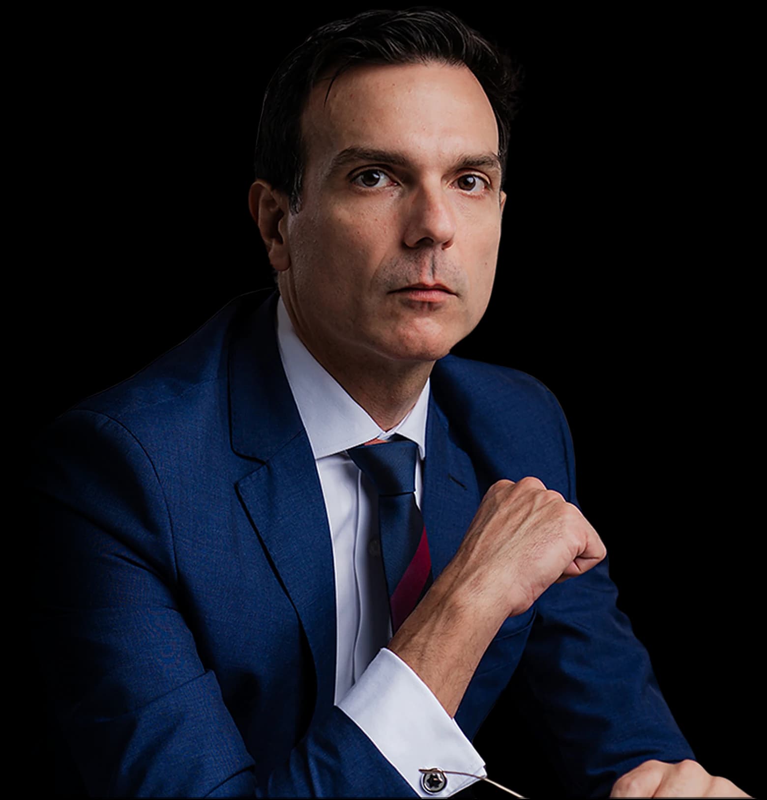 Rodrigo Baraldi, de terno azul-marinho, olhando para a câmera